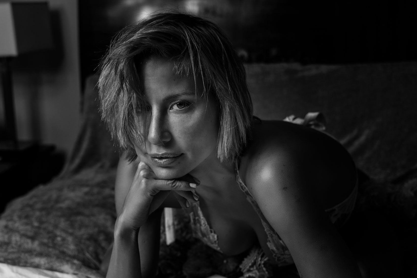 Black and white cinematic portrait of a woman resting her chin on her hand — visual identity photography